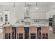 Close up of large kitchen island with sink, seating and modern pendant lighting at 8328 Sea Glass Ct, Sarasota, FL 34240
