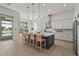 Gourmet kitchen with large center island, stainless appliances, and views of the pool and lake at 8328 Sea Glass Ct, Sarasota, FL 34240