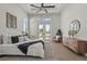 Comfortable main bedroom featuring a tray ceiling, fan, and patio doors, with a pond view at 8328 Sea Glass Ct, Sarasota, FL 34240