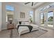 Bright main bedroom with a decorative rug, white bedding, and French doors leading to a patio overlooking a pond at 8328 Sea Glass Ct, Sarasota, FL 34240