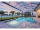 Screened-in pool with a lovely view of the lake surrounded by green grass and multiple palm trees at 8328 Sea Glass Ct, Sarasota, FL 34240