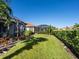 Spacious backyard with grassy area and screened enclosure at 8752 Bellussi Dr, Sarasota, FL 34238