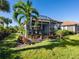 Landscaped backyard with patio and lush tropical plants at 8752 Bellussi Dr, Sarasota, FL 34238