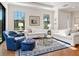Living area with hardwood floors, white sofas, and blue armchairs at 8752 Bellussi Dr, Sarasota, FL 34238