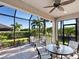 Screened patio with seating area and view of lush landscaping at 8752 Bellussi Dr, Sarasota, FL 34238