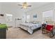 Main bedroom with ceiling fan, carpeting, and access to bathroom at 9016 Waxwing Way, Parrish, FL 34219