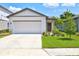 Newly constructed home with a white exterior, two-car garage, and landscaped front yard at 9016 Waxwing Way, Parrish, FL 34219