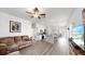 Open living room with kitchen view, brown sofas, and wood-look floors at 9016 Waxwing Way, Parrish, FL 34219
