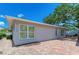 House exterior showcasing a light gray color, brick pavers, and lush landscaping at 1125 N Moonmist Ct # L5, Sarasota, FL 34242
