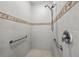 Modern bathroom features tiled walls, handrails, and an updated shower head at 1743 Pinyon Pine Dr, Sarasota, FL 34240
