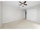 A light-filled bedroom featuring neutral walls, a ceiling fan, and a closet with classic doors at 1743 Pinyon Pine Dr, Sarasota, FL 34240