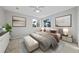 A staged bedroom with neutral decor, a queen bed, and bright natural light at 1743 Pinyon Pine Dr, Sarasota, FL 34240