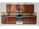 A kitchen boasts wood cabinets, stainless steel appliances, and tile backsplash at 1743 Pinyon Pine Dr, Sarasota, FL 34240