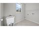 Clean laundry room featuring a utility sink, tiled floor, and convenient shelf storage at 1743 Pinyon Pine Dr, Sarasota, FL 34240