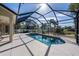 Screened pool with an attached spa surrounded by a large patio area and lush landscaping at 1743 Pinyon Pine Dr, Sarasota, FL 34240