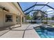 View of the pool and patio with a screened enclosure, steps to the spa, and a ceiling fan at 1743 Pinyon Pine Dr, Sarasota, FL 34240