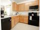 Modern kitchen featuring light wood cabinets and black appliances at 1877 Dragonfly Ave, North Port, FL 34288