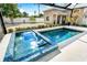 A backyard features a pristine pool and spa with mosaic tile accents, as well as professional landscaping at 2326 Gull Ln, Sarasota, FL 34237