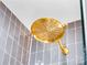 Close-up of a gold shower head in a gray tiled shower at 2326 Gull Ln, Sarasota, FL 34237