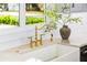 Close up of a farmhouse sink featuring a stylish gold faucet and light countertops at 2326 Gull Ln, Sarasota, FL 34237