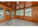 Sunroom with wood paneling, neutral carpet, and large windows at 3128 Bay St, Sarasota, FL 34237