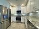 Modern kitchen with white cabinets, granite countertops, and stainless steel appliances at 3404 79Th Street W Cir # 203, Bradenton, FL 34209
