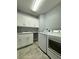 Bright laundry room, featuring white cabinets, granite countertops, and a washer and dryer at 3404 79Th Street W Cir # 203, Bradenton, FL 34209