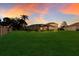 Spacious backyard with screened patio and lush landscaping at sunset at 3618 Summerwind Cir, Bradenton, FL 34209