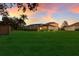 Spacious backyard with screened patio and lush landscaping at sunset at 3618 Summerwind Cir, Bradenton, FL 34209