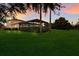 Large backyard with screened patio, landscape, and sunset view at 3618 Summerwind Cir, Bradenton, FL 34209