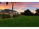 Screened patio and lush landscaping in backyard at sunset at 3618 Summerwind Cir, Bradenton, FL 34209
