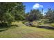 Serene backyard view featuring a natural creek and tree-lined landscape at 3618 Summerwind Cir, Bradenton, FL 34209