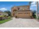 Two-story house with a tan exterior, two-car garage, and landscaped yard at 3618 Summerwind Cir, Bradenton, FL 34209
