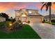 Two-story house with a tan exterior, two-car garage, and landscaped yard at 3618 Summerwind Cir, Bradenton, FL 34209