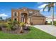 Two-story house with a tan exterior, two-car garage, and landscaped yard at 3618 Summerwind Cir, Bradenton, FL 34209