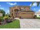 Two-story house with a tan exterior, two-car garage, and landscaped yard at 3618 Summerwind Cir, Bradenton, FL 34209