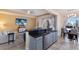 Open concept kitchen and living area with breakfast bar, gray cabinets, and tiled floors at 3618 Summerwind Cir, Bradenton, FL 34209