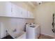 Laundry room with white cabinets, washer, dryer, and utility sink at 3618 Summerwind Cir, Bradenton, FL 34209