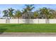 Large backyard with a white wall and green grass at 3808 El Conquistador Pkwy, Bradenton, FL 34210