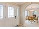 Bright entryway with a white door and arched openings to living and dining areas at 3808 El Conquistador Pkwy, Bradenton, FL 34210