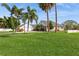 Landscaped front yard with lush green grass and palm trees at 3808 El Conquistador Pkwy, Bradenton, FL 34210