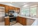 Kitchen boasts wood cabinets, stainless steel appliances, and a sunny window at 3808 El Conquistador Pkwy, Bradenton, FL 34210