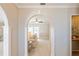 View through arched doorway showing living room with neutral decor and access to backyard at 3808 El Conquistador Pkwy, Bradenton, FL 34210