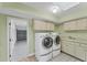 Bright laundry room with washer, dryer, and cabinets at 3911 Torrey Pines Blvd, Sarasota, FL 34238