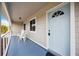 Side view of the front porch with light blue door and white chairs at 3915 32Nd W St, Bradenton, FL 34205