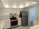 Bright kitchen features new stainless steel refrigerator, oven, and white cabinets and countertops at 3935 Panola Ln # 183, Sarasota, FL 34232