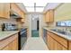 A well-lit kitchen with stainless steel appliances, wood cabinetry, and granite countertops at 4423 Meadow Creek Cir, Sarasota, FL 34233