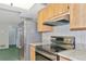 Galley kitchen featuring stainless appliances, granite counters, and wood cabinets at 4423 Meadow Creek Cir, Sarasota, FL 34233