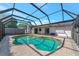 Screened-in pool area with a kidney-shaped pool and brick paving, great for outdoor relaxation at 4423 Meadow Creek Cir, Sarasota, FL 34233