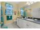 Sunny bathroom with yellow walls, patterned window curtains, and a white vanity with a sink at 4423 Via Del Villetti Dr, Venice, FL 34293